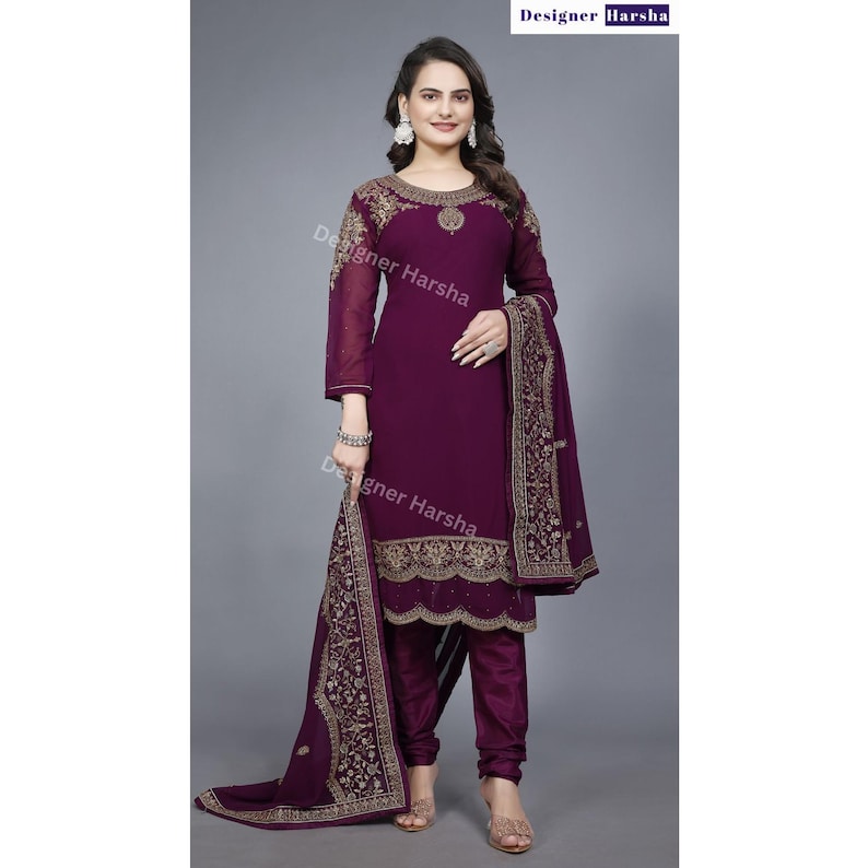 Puede incluir: Un salwar kameez morado con bordados dorados. El kameez tiene mangas largas y un escote redondo. El salwar es un pantal&oacute;n que se ajusta a la cintura y es holgado en los tobillos. El dupatta es una larga bufanda que a menudo se usa con un salwar kameez.