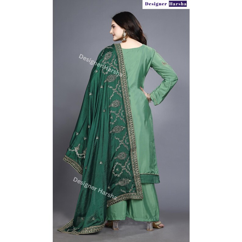 May include: A green and light green salwar kameez with embroidery. The kameez has long sleeves and a high neckline. The salwar is wide-legged and the dupatta is a long, flowing scarf.