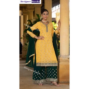 Puede incluir: Un vestido bordado amarillo y verde con una parte superior de manga larga y pantalones palazzo. El vestido tiene un escote en V y bordados dorados. Los pantalones son verdes con bordados dorados. El vestido se combina con un dupatta verde.