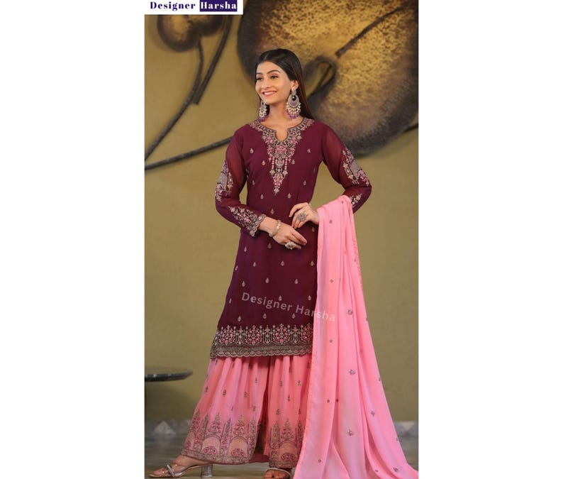 May include: A maroon and pink salwar kameez with embroidery. The kameez has long sleeves and a round neckline. The salwar is pink and has a printed design. The dupatta is pink and has a plain design. The text "Designer Harsha" is visible on the image.