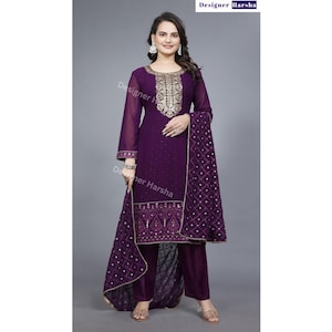 May include: A deep purple salwar kameez ensemble. The outfit features a long-sleeved tunic with gold embroidery around the neckline and cuffs, matching pants, and a patterned scarf. The text "Designer Harsha" is visible at the top.