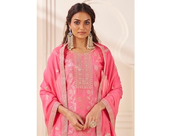 May include: A bright pink salwar kameez set featuring a tunic with intricate gold embroidery around the neckline and a matching dupatta with a decorative border. The text Designer Harsha is visible at the top of the image.