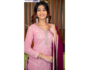 Può includere: Una donna indossa una kurta ricamata rosa con un dupatta marrone. La kurta ha una scollatura a V ed è decorata con ricami argentati. Il dupatta è drappeggiato sulle sue spalle e ha un bordo dorato.