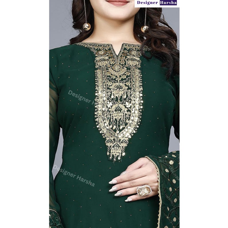 May include: A dark green long-sleeved dress with gold embroidery and sequins. The dress has a V-neckline and a fitted silhouette.