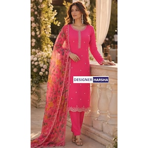 Puede incluir: Una t&uacute;nica de color rosa brillante de manga larga con cuello redondo y bordado vertical, combinada con pantalones rosas a juego y un dupatta rosa transparente con un estampado floral multicolor. El texto DESIGNER HARSHA es visible.