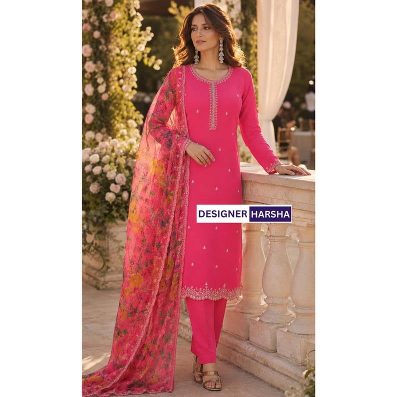 Puede incluir: Una t&uacute;nica de color rosa brillante de manga larga con cuello redondo y bordado vertical, combinada con pantalones rosas a juego y un dupatta rosa transparente con un estampado floral multicolor. El texto DESIGNER HARSHA es visible.