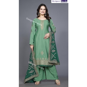 May include: A green salwar kameez with gold embroidery and a matching green dupatta. The dupatta has a gold border and a floral design.