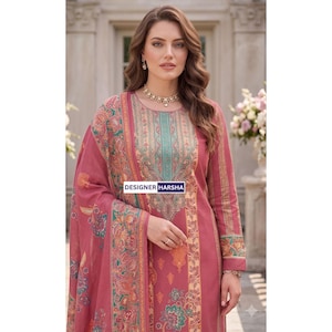 May include: A long-sleeved, rose-pink tunic featuring a central panel with intricate teal and gold floral patterns, a round neckline, and a matching shawl draped over one shoulder. The garment displays the text DESIGNER HARSHA in a blue box.