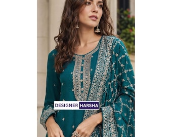 May include: A teal long-sleeved tunic featuring intricate silver embroidery along the neckline and cuffs, paired with a matching teal dupatta with silver floral patterns. The text DESIGNER HARSHA is printed in a white box on the garment.