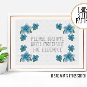 May include: Cross stitch pattern with blue flowers and the text "PLEASE URINATE WITH PRECISION AND ELEGANCE". The pattern is titled "IT SAID WHAT? CROSS STITCH".