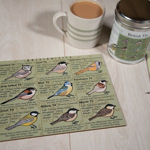 May include: A wooden puzzle featuring illustrations of different British tit birds, including the Crested Tit, Long-tailed Tit, Great Tit, Coal Tit, Blue Tit, Willow Tit, Bearded Tit, Penduline Tit, and Marsh Tit. Each bird is labeled with its name, call, wingspan, length, and weight in inches and grams. The puzzle is part of a collection called "British Tits" and is made by Heirloom Wooden Puzzles.