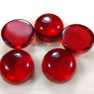 Puede incluir: Cinco piedras preciosas redondas de cabujón rojo. Las piedras preciosas son lisas y pulidas, con un acabado brillante. Gems For Jaipur.