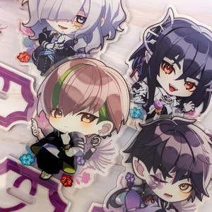 Könnte beinhalten: Vier Acryl-Anime-Charakter-Aufsteller. Jeder Aufsteller zeigt einen Charakter im Chibi-Stil mit einzigartigen Haaren und Kleidung. Die Aufsteller stehen auf lila dekorativen Sockeln. Der Hintergrund ist ein helles Marmormuster.