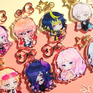 Könnte beinhalten: Eine Sammlung von acht durchsichtigen Acryl-Schlüsselanhängern mit farbenfrohen Chibi-Anime-Figuren. Jeder Anhänger verfügt über einen Metallverschluss in Herz- oder Sternform. Die Figuren zeigen verschiedene Haarfarben, Outfits und Gesichtsausdrücke.