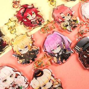 May include: A collection of nine acrylic keychains featuring colorful chibi-style anime characters with diverse hair colors and outfits. Each charm includes a gold-toned metal star or flower-shaped clasp attached to the top of the clear acrylic figure.