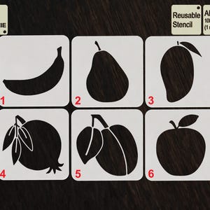 May include: A set of six reusable stencils for cookie decorating, featuring fruit shapes: banana, pear, mango, pomegranate, plum, and apple. The stencils are made of APET material, 1 mm thick, and labeled with numbers. The text "TOOL FOR COOKIE" is also visible.