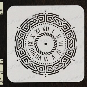 May include: A white reusable stencil with a black clock design featuring Roman numerals and a geometric pattern. The stencil is made of 1000 micron APET plastic, which is 1 mm thick.
