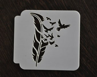 Könnte beinhalten: Eine weiße Kunststoffschablone mit einer schwarzen Silhouette einer Feder und Vögeln, die davon fliegen.