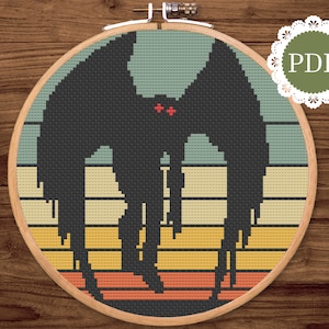 May include: Cross-stitch pattern featuring a black silhouette of a creature with large wings and red eyes, set against a retro striped background in shades of teal, yellow, and orange. The design is framed in a wooden embroidery hoop, with a PDF icon.