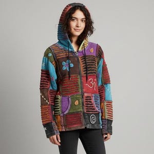 May include: A colourful patchwork zip-up hoodie with a hood. The jacket features a variety of colours, including blue, brown, red, and purple. The front of the jacket has a floral design and a symbol. The jacket is made of a soft material.