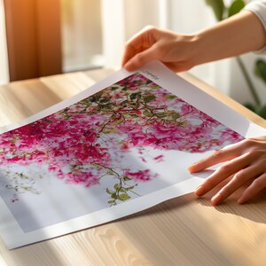May include: A close-up of a printed photograph featuring a vibrant pink flower cluster with green leaves against a white background.
