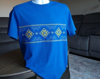 May include: A blue t-shirt with a yellow and blue geometric pattern across the chest.