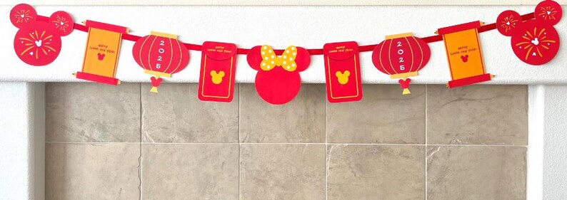 Puede incluir: Guirnalda de papel roja y amarilla con personajes de Mickey Mouse y Minnie Mouse, linternas y rollos. La guirnalda dice "Feliz A&ntilde;o Nuevo Lunar" y "2023".