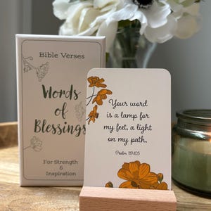 May include: A set of "Words of Blessings" Bible verse cards with a wooden card holder. The cards feature floral illustrations and the text "Your word is a lamp for my feet, a light on my path. Psalm 119:105."
