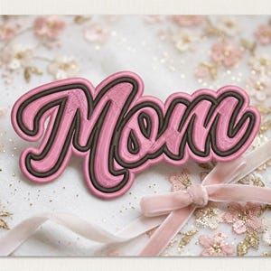Puede incluir: Aplicación bordada en rosa con la palabra "Mom" en letras cursivas, contorneada en marrón oscuro. Sobre un fondo de encaje floral y una cinta rosa. Ideal para manualidades o regalos.