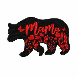 Peut inclure: Écusson noir en forme d'ours avec le mot rouge "Mama" brodé en haut. Des fleurs et des papillons rouges sont brodés sur le corps de l'ours. L'écusson est conçu pour les vêtements et les accessoires.