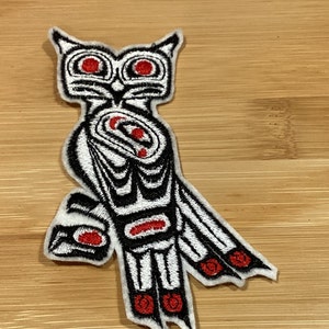 May include: Embroidered owl patch in a Native American design. The patch features a white owl with black outlines and red accents on a light brown background. The owl has large, round eyes and detailed wing patterns.