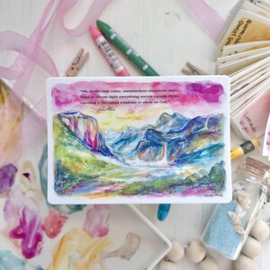 May include: A rectangular watercolor art print featuring a mountain landscape with a waterfall, in shades of blue, green, and pink. The print includes a quote about nature and spirituality. Additional items include crayons, a palette, and decorative elements.