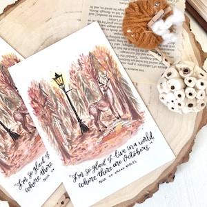 May include: A watercolor illustration of a deer in a forest with a street lamp. The quote "I'm so glad I live in a world where there are Octobers." from Anne of Green Gables is written below the image.