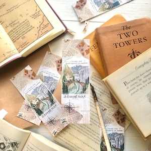 May include: A set of four bookmarks featuring a watercolor illustration of a bridge with mountains in the background. The bookmarks are printed on a collage of vintage paper with the text "I think I am quite ready for another adventure".