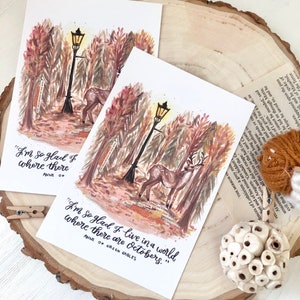 May include: A watercolor illustration of a forest scene with a deer and a streetlight. The quote "I'm so glad I live in a world where there are Octobers." is written below the image. The quote is attributed to Anne of Green Gables.