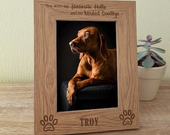 May include: A wooden photo frame with a paw print design and the inscription "You were my favourite Hello and my hardest Goodbye". The frame has a photo of a brown dog and the name "TROY" engraved below the photo.