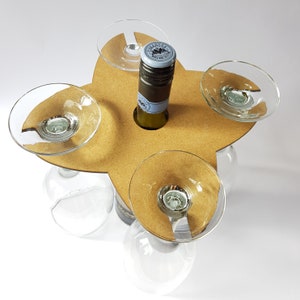 May include: Wooden wine bottle holder with four glass holders. The holder is shaped like a four-leaf clover. The bottle holder is brown and the glass holders are clear.