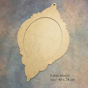 Pode incluir: Uma placa de madeira grande, n&atilde;o pintada, com um recorte oval no centro. A placa tem uma borda decorativa e adornada e um furo na parte superior para pendurar. Mede 44 x 28 cm.