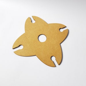 May include: A wooden wine bottle holder shaped like a four-pointed star with cutouts for holding bottles.