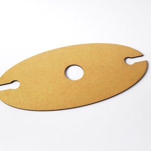 May include: A light brown wooden wine bottle holder with two cutouts for holding bottles and a circular cutout in the center.