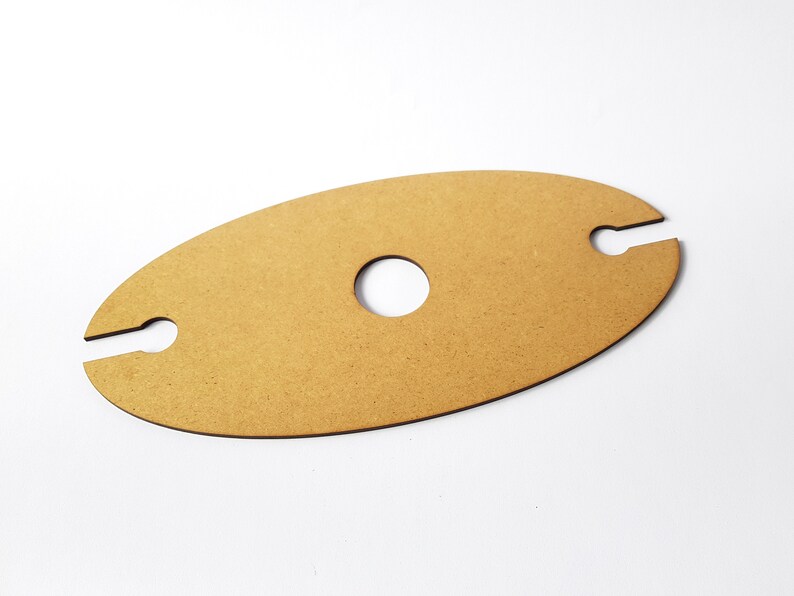 May include: A light brown wooden wine bottle holder with two cutouts for holding bottles and a circular cutout in the center.
