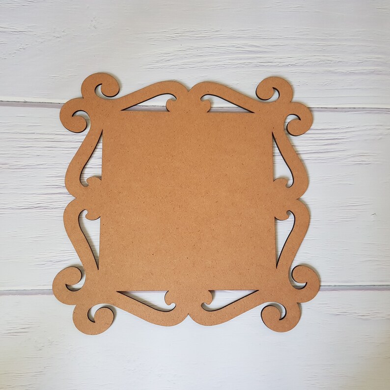 May include: A brown wooden frame with a decorative, ornate design. The frame is blank and ready for a picture or artwork.