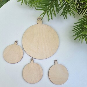 May include: Four unfinished wooden ornaments shaped like Christmas tree ornaments. The ornaments are different sizes and are ready to be painted or decorated.