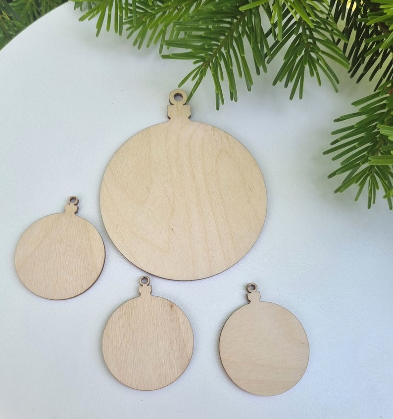 May include: Four unfinished wooden ornaments shaped like Christmas tree ornaments. The ornaments are different sizes and are ready to be painted or decorated.