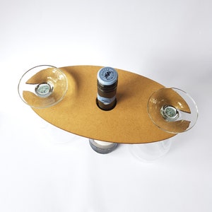 May include: A wooden wine and glass holder with two glass holders and a bottle holder. The holder is brown and has a natural wood finish.