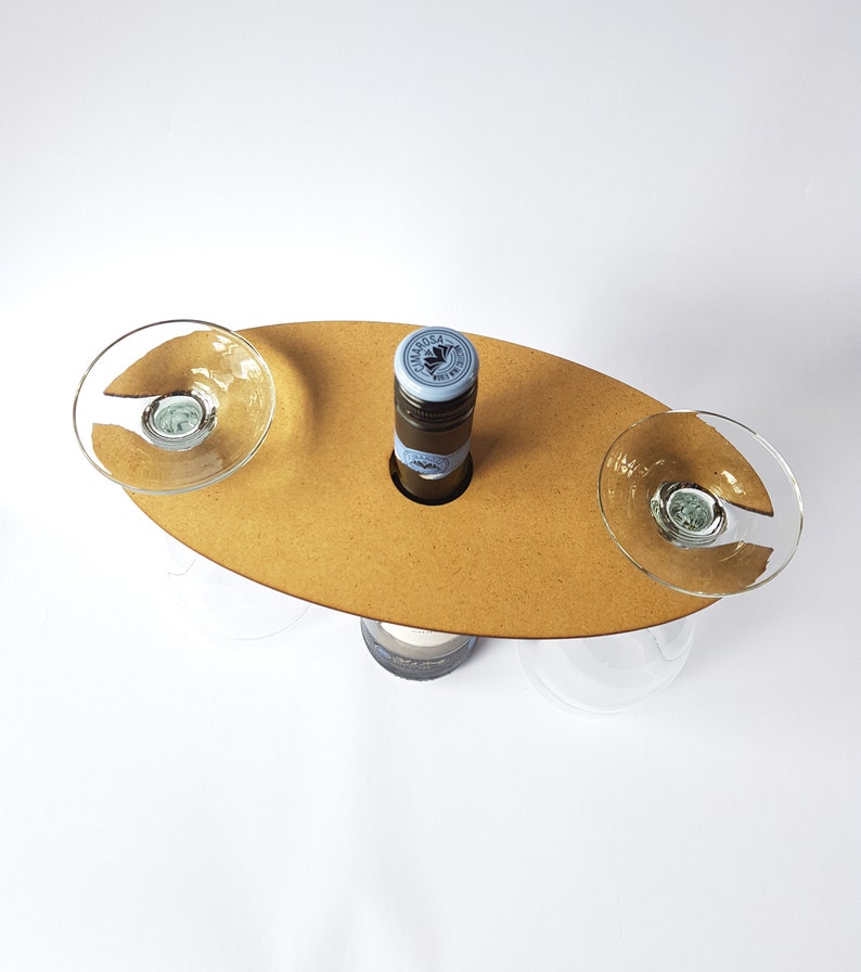 May include: A wooden wine and glass holder with two glass holders and a bottle holder. The holder is brown and has a natural wood finish.