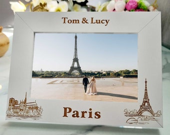May include: White picture frame with a photo of the Eiffel Tower in Paris, France. The frame has the names "Tom & Lucy" and the word "Paris" engraved on it.