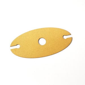 May include: A wooden wine bottle holder in the shape of an oval with two cutouts for holding bottles and a circular cutout in the center.