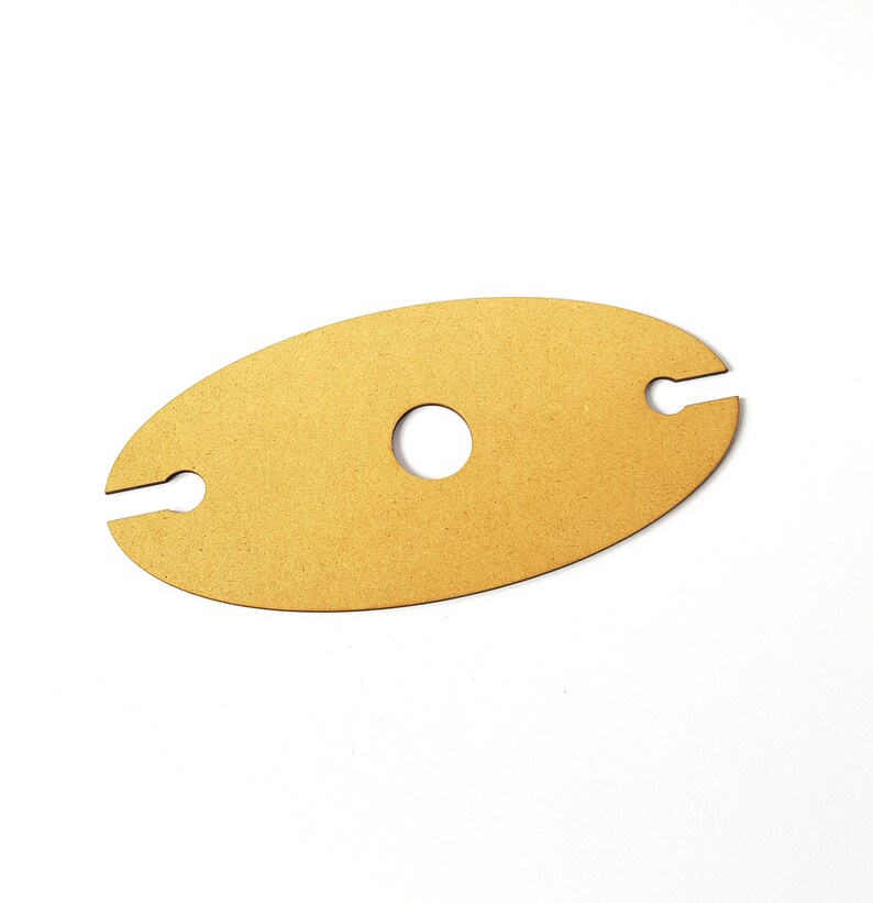 May include: A wooden wine bottle holder in the shape of an oval with two cutouts for holding bottles and a circular cutout in the center.