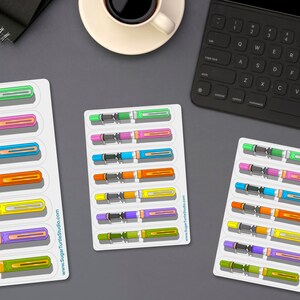May include: A set of six colorful fountain pen stickers. The stickers are arranged in rows of two on a white background. The pens are all different colors, including green, pink, blue, orange, yellow, and purple. The stickers are perfect for adding a touch of personality to your planner, laptop, or water bottle.
